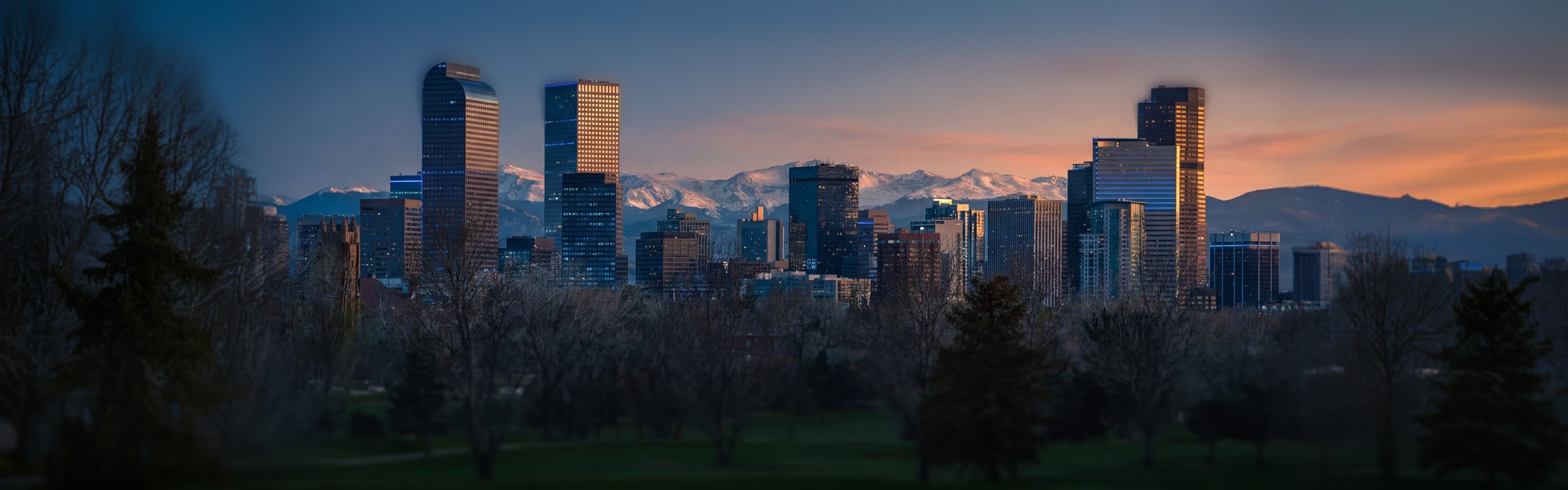 Denver skyline with downtown towers and mountain backdrop - managed Wi-Fi, fiber internet, and bulk TV services for Denver multifamily properties